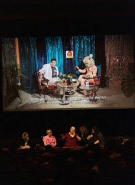 Foto von Panelgästen und Moderation auf der Bühne im Statdkino Wien.
