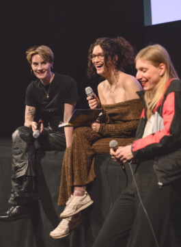 Foto von Panelgästen und Moderation auf der Bühne im Stadtkino Wien 